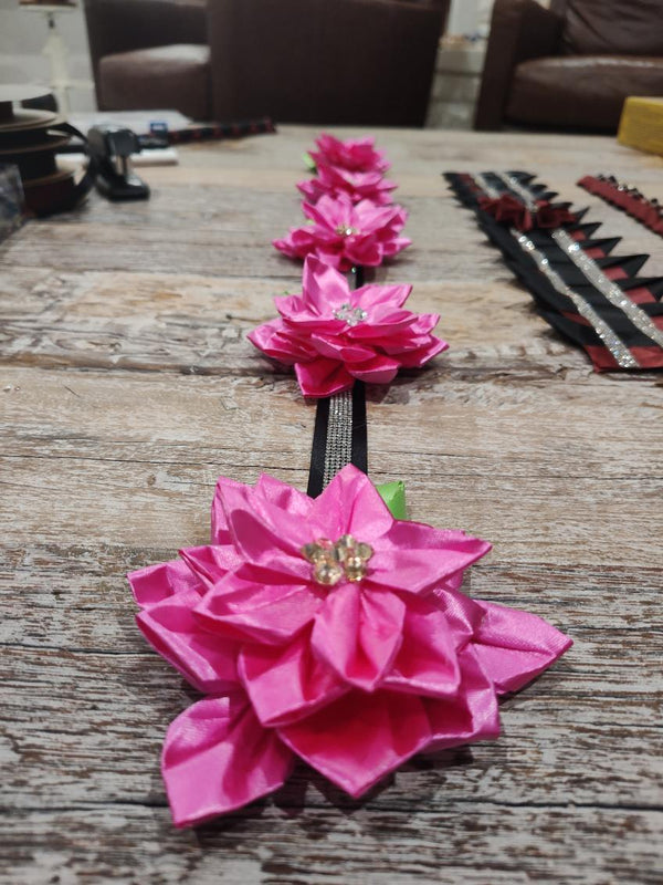 Hot pink satin flowers on a black rhinestone strip, a handmade accent for a homecoming mum