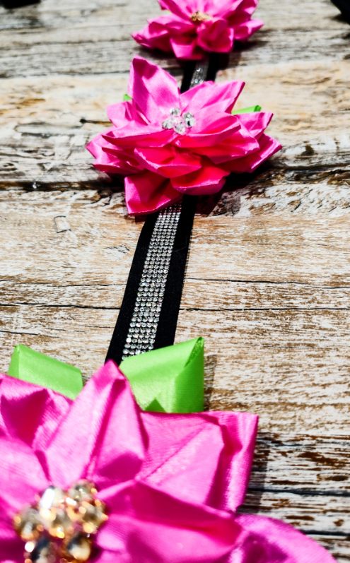 Hot pink satin flowers with jeweled centers on a black rhinestone ribbon, a homecoming mum accent